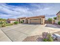 Sprawling ranch-style home featuring a wide driveway with desert landscaping, complemented by a tile roof and an attached two-car garage at 18249 W Mauna Loa Ln, Surprise, AZ 85388