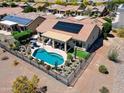 Aerial view of a single Gathering home with a pool, desert landscaping, and solar panels in a golf course community at 20655 N 273Rd Ave, Buckeye, AZ 85396