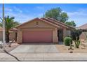 Single-story house with a two-car garage, desert landscaping, and concrete driveway at 2467 E Winchester Pl, Chandler, AZ 85286