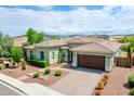 Beautiful one-story home with lush landscaping, a brick paver driveway, and a two-car garage at 30909 N 27Th Ave, Phoenix, AZ 85085