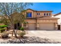 Two-story home featuring a three-car garage, stone accents, and a beautiful desert landscaped front yard at 31604 N 19Th Ave, Phoenix, AZ 85085