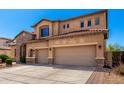 Two-story home featuring a three-car garage, stone accents, and a beautiful desert landscaped front yard at 31604 N 19Th Ave, Phoenix, AZ 85085