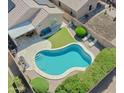 Aerial view of a private backyard oasis, featuring a sparkling pool, covered patio, and lush green landscaping at 3612 W Charlotte Dr, Glendale, AZ 85310