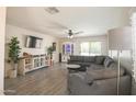 Inviting living room with hardwood floors, a comfortable gray sofa, and plenty of natural light at 3612 W Charlotte Dr, Glendale, AZ 85310