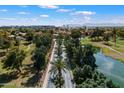 Aerial shot of a street lined with palm trees surrounded by lush landscaping and water features at 3671 S Greythorne Way, Chandler, AZ 85248