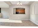 Open living space with tile floors, showcasing the kitchen through an arched pass-through at 3820 E Mcdowell Rd # 102, Phoenix, AZ 85008