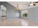 Bright dining room with tile floors, gray walls, a modern chandelier, and a view to the exterior at 3898 E San Remo Ave, Gilbert, AZ 85234