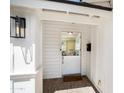 Charming white door and brick entryway with a lantern and view into the home at 4916 E Flower St, Phoenix, AZ 85018