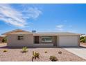 Single story home with desert landscaping, a concrete driveway and an attached two car garage at 6043 E Des Moines St, Mesa, AZ 85205