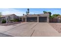 Lovely single-story home boasting a low-maintenance yard and a large paved driveway leading to an attached two-car garage at 6126 E Paradise Ln, Scottsdale, AZ 85254