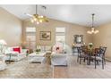 Bright living room featuring high ceilings, a ceiling fan, and comfortable seating with a seamless flow to the dining area at 6713 E Riverdale St, Mesa, AZ 85215