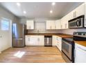 Bright kitchen features stainless appliances, wood-look floors and white cabinets at 1219 E Colter St # 8, Phoenix, AZ 85014