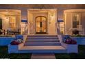 Inviting front entrance with decorative columns, accent lighting, and flower planters at 1379 S Claiborne Ave, Gilbert, AZ 85296
