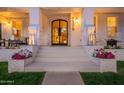 Charming front entrance featuring a brick facade, decorative lighting, and potted flowers on the steps at 1379 S Claiborne Ave, Gilbert, AZ 85296