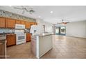Bright kitchen with light wood cabinets, white appliances, and an adjoining open living space at 14625 W Redfield Rd, Surprise, AZ 85379