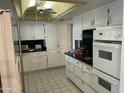 Bright kitchen with white cabinets, tile flooring, and stainless steel appliances at 15438 N Lakeforest Dr, Sun City, AZ 85351