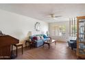 Bright living room featuring a comfortable blue sofa, ceiling fan, and wood laminate flooring at 15438 N Lakeforest Dr, Sun City, AZ 85351