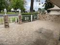 View of the covered patio with brick columns, ornate white fence and tile flooring at 15438 N Lakeforest Dr, Sun City, AZ 85351