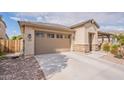 Charming stucco home featuring a two-car garage, desert landscaping, and covered entry with stone accents at 3720 E Narrowleaf Dr, Gilbert, AZ 85298