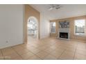 Bright living room with a painted brick fireplace and arched doorway leading to the kitchen at 702 W Sequoia Dr, Phoenix, AZ 85027