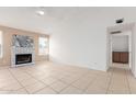 Spacious living room featuring tile flooring, a cozy fireplace, and neutral walls at 702 W Sequoia Dr, Phoenix, AZ 85027