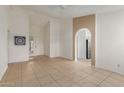 Spacious living area with neutral tile flooring and arched access to the kitchen at 702 W Sequoia Dr, Phoenix, AZ 85027