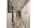 Long hallway showcases modern tile flooring and stylish wall art, leading to various rooms at 7616 W Jones Ave, Phoenix, AZ 85043