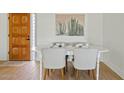 Cozy dining room with a white table set for four, a wooden door, and cactus-themed wall art at 8144 E Vista Dr, Scottsdale, AZ 85250