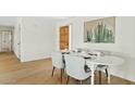 Cozy dining room featuring a white table set for four, a wooden door, and cactus-themed wall art at 8144 E Vista Dr, Scottsdale, AZ 85250