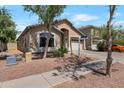 View of the property showing the manicured yard and two-car garage at 8524 S 49Th Ln, Laveen, AZ 85339