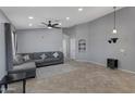 Bright living room with a sectional sofa, ceiling fan, and tiled floors at 8524 S 49Th Ln, Laveen, AZ 85339