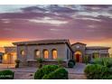 Beautiful home with desert landscaping, stone accents, and a tiled roof during a colorful sunset at 10934 E La Verna Way, Scottsdale, AZ 85262