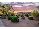 Desert landscaping surrounds a stunning home beneath a vibrant sunset sky at 10934 E La Verna Way, Scottsdale, AZ 85262