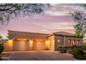 Tiled roof home with three-car garage and desert landscaping at dusk at 10934 E La Verna Way, Scottsdale, AZ 85262