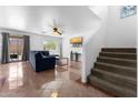 Comfortable living room featuring tile floors, a ceiling fan, and ample natural light at 10939 W Meadowbrook Ave, Phoenix, AZ 85037