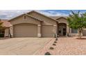 Single-story home features neutral stucco, low maintenance desert landscaping, and a convenient three-car garage at 11010 W Palm Ln, Avondale, AZ 85392