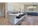 Modern kitchen featuring an island with bar seating, stainless appliances, and hardwood floors at 12225 E Cortez Dr, Scottsdale, AZ 85259