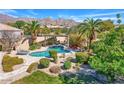 Backyard pool with a manicured lawn, mature landscaping, and an outdoor lounge area at 12225 E Cortez Dr, Scottsdale, AZ 85259