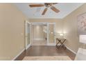 Bedroom with wood floors and ceiling fan offers a view into the open hallway and staircase at 14010 N 126Th Ave, El Mirage, AZ 85335