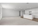 Bright, open living area with neutral carpet, recessed lighting, and connected kitchen at 1409 E Jacqueline Pl, Casa Grande, AZ 85122