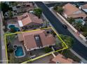 Aerial view of a home with a private pool and spa, bordered by lush greenery, and a yellow property outline at 14248 N 56Th Pl, Scottsdale, AZ 85254