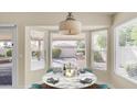 Bright dining area featuring a round table, backyard views, and natural light from three windows at 14248 N 56Th Pl, Scottsdale, AZ 85254