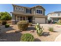 Beautiful two-story home with a well-manicured front yard, desert landscaping, and a spacious two-car garage at 15010 W Hope Dr, Surprise, AZ 85379