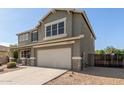 Side view of home with a two-car garage, showcasing the well-maintained exterior and landscaping at 15010 W Hope Dr, Surprise, AZ 85379
