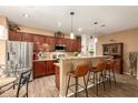 Charming kitchen with bar seating, wooden cabinets, granite countertops, and stainless appliances at 17797 W Statler Dr, Surprise, AZ 85388
