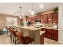 Spacious kitchen with a breakfast bar, rich wood cabinetry, and stainless steel appliances at 17797 W Statler Dr, Surprise, AZ 85388