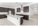 Stylish kitchen with dark cabinets, stainless steel hood, white countertops, and modern fixtures at 21838 E Bonanza Ct, Queen Creek, AZ 85142