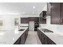 Sleek, modern kitchen with stainless steel appliances, dark cabinetry, and a large center island at 21838 E Bonanza Ct, Queen Creek, AZ 85142