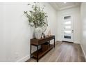 Bright and airy entryway featuring wood floors, a wood console table, modern decor, and a door with windows at 2885 N 164Th Dr, Goodyear, AZ 85395