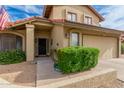 Entrance with a tan exterior, front porch, and trimmed bushes at the entry at 6019 E Paradise Ln, Scottsdale, AZ 85254